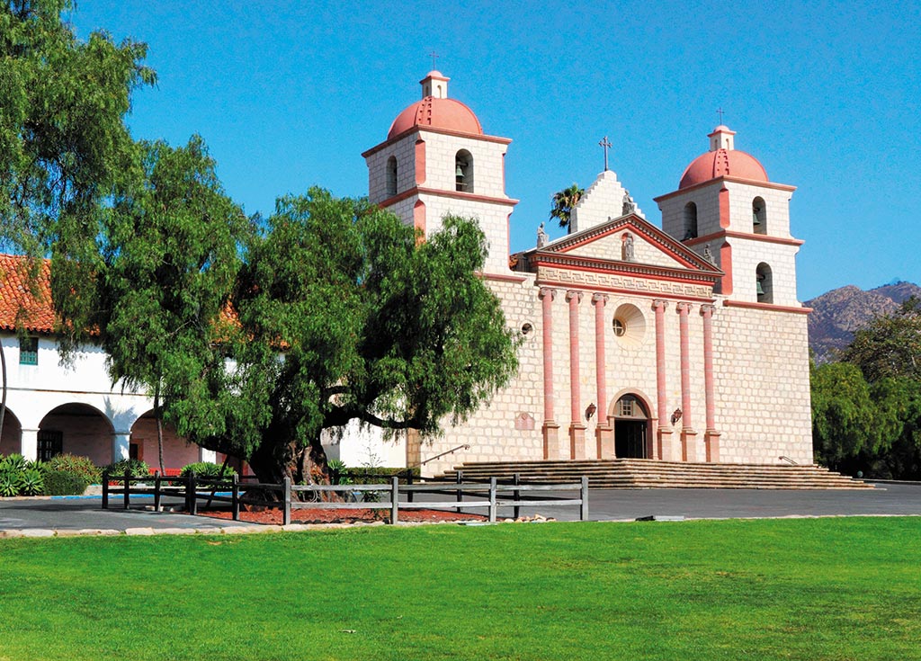 a mission with green lawn and trees