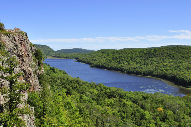 Overlook of a verdant valley and blue lake.