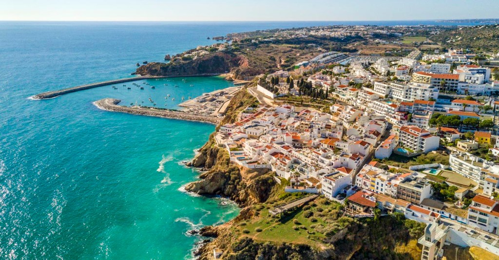 Aerial view of ocean, marina, buildings and cliffs in Albufeira, Algarve, Portugal.