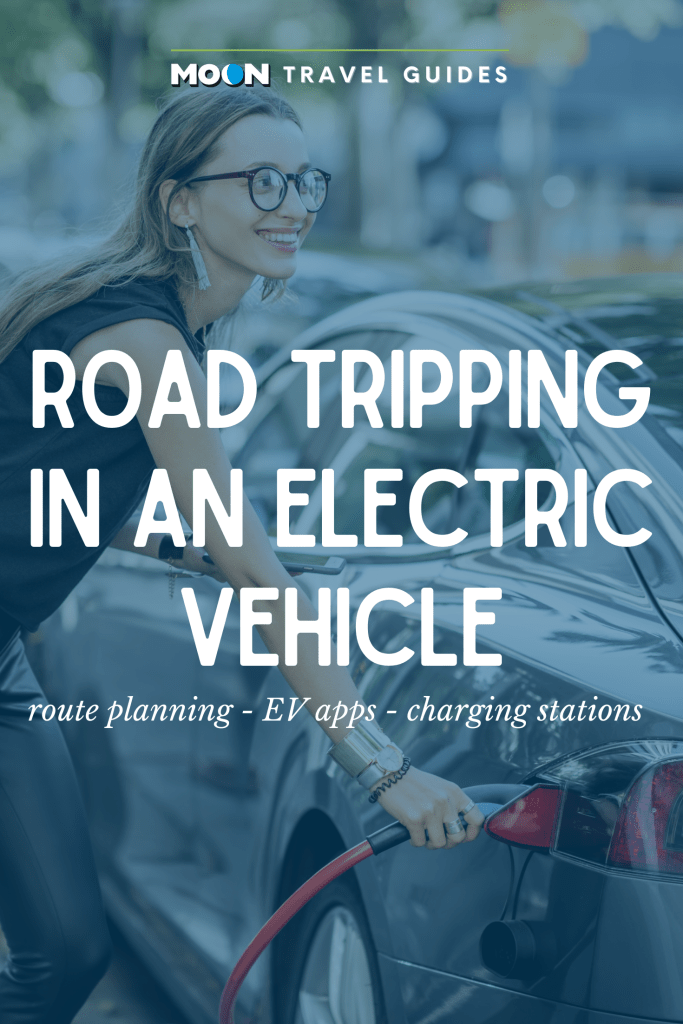 A woman charges her electric vehicle at a charging station